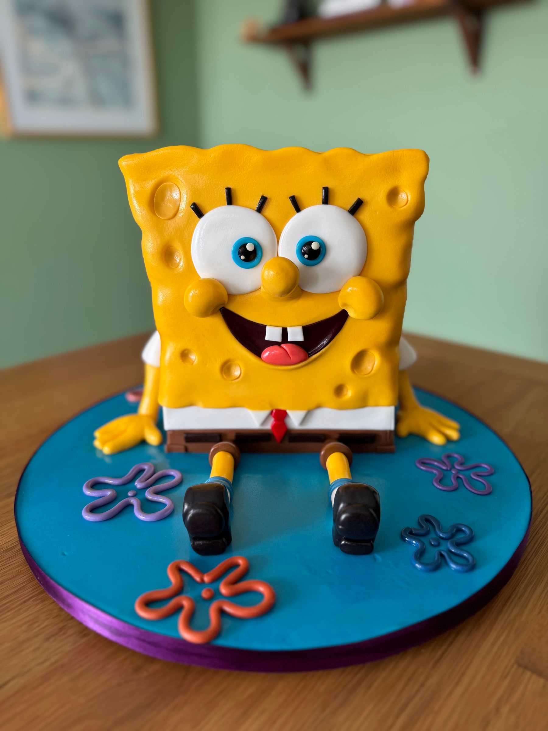 Bolo escultórico do Bob Esponja em pasta americana amarela texturizada, sobre base azul